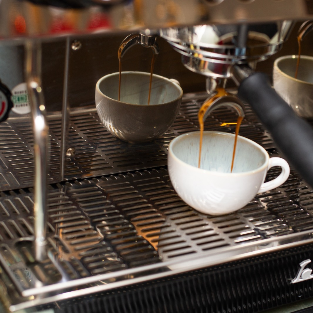 Espressomaschine bei CIN CIN gießt frischen Espresso in zwei Tassen