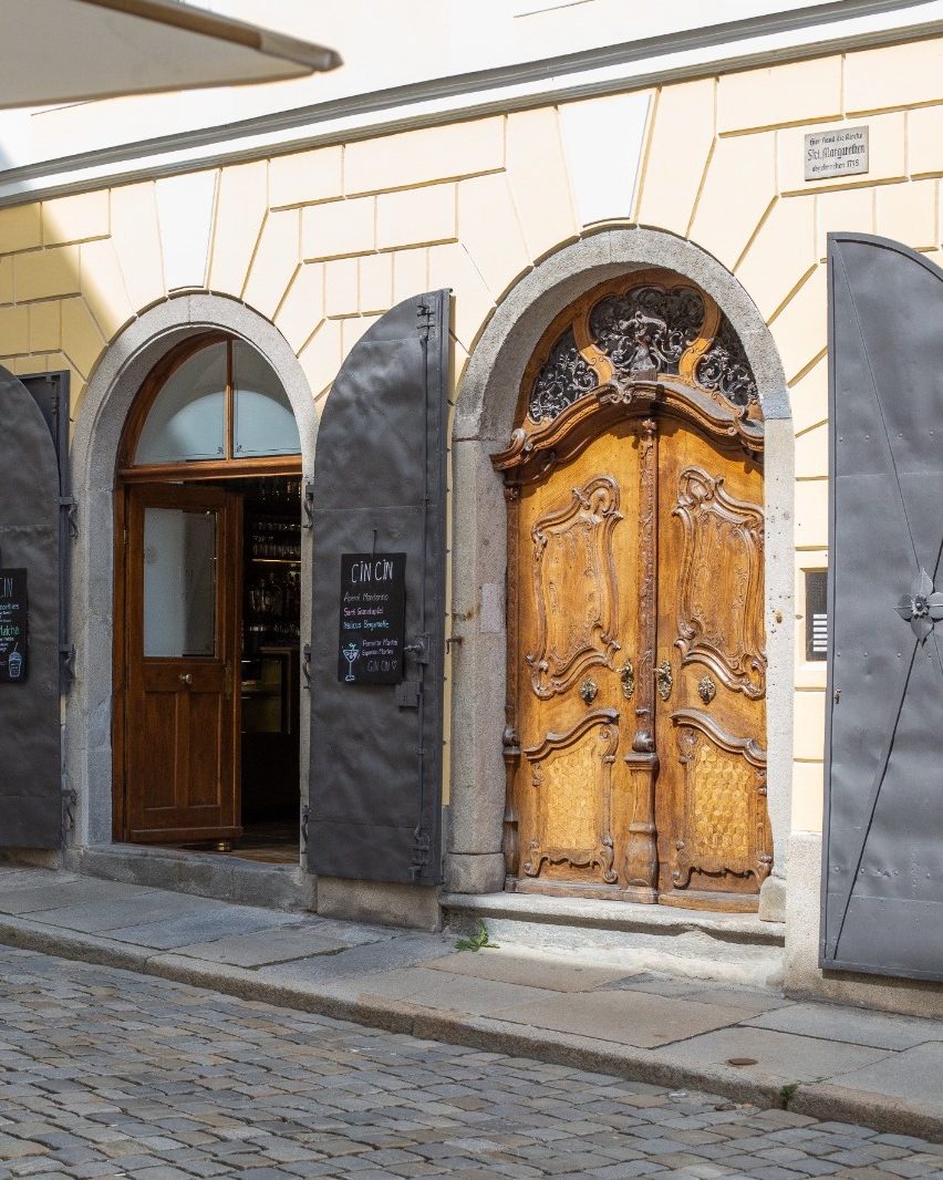 Eingang des Café-Bar CIN CIN in der Großen Messergasse in Passau mit historischer Holztür