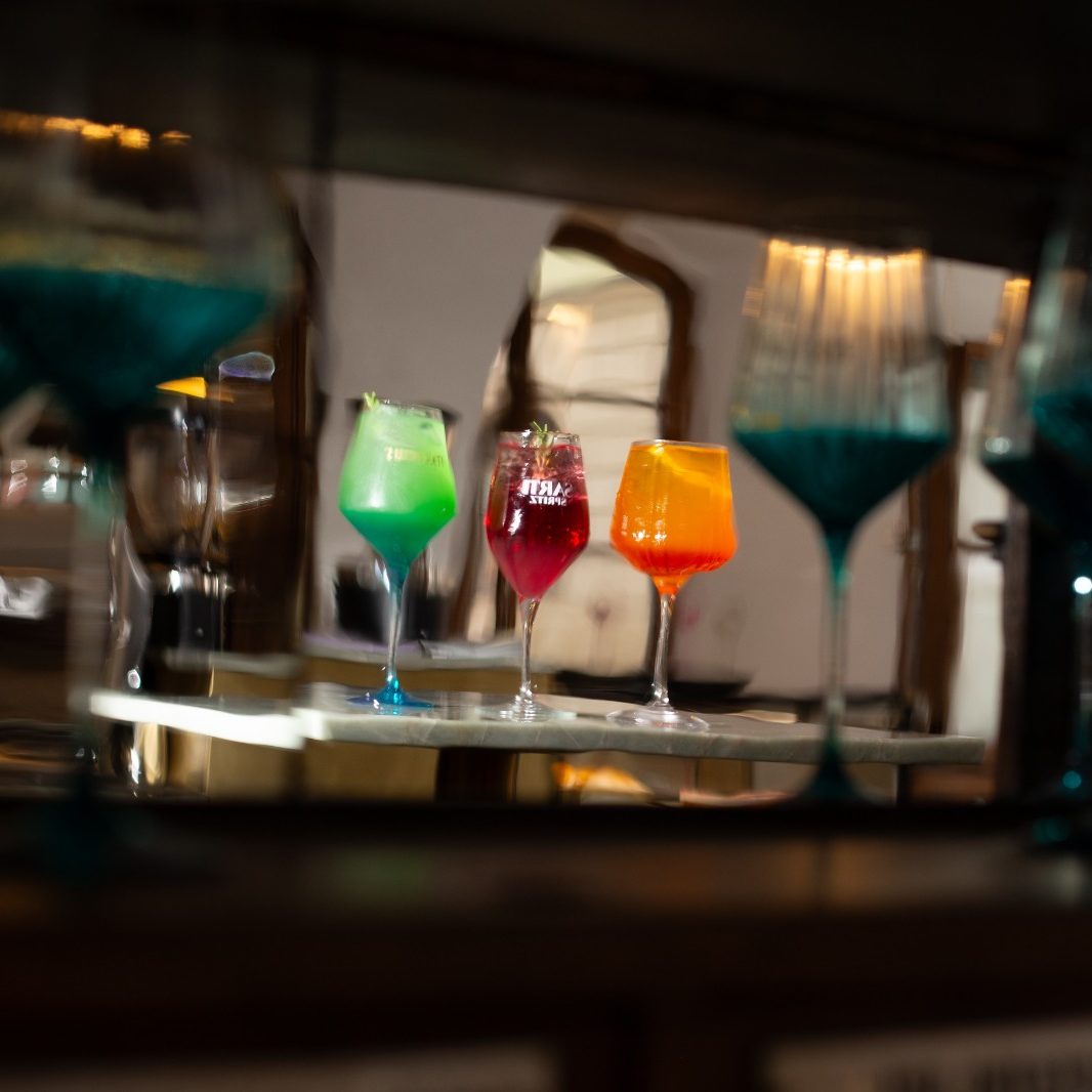 Bunte Cocktailgläser spiegeln sich unscharf an der Bar von CIN CIN